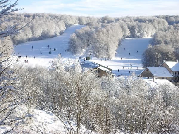 Station de Brameloup en hiver avec pistes enneigées et paysages de l’Aubrac.