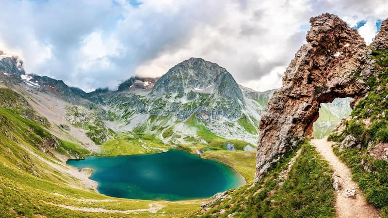 Paysage de montagne dans l’Oisans avec un lac d’altitude et des sommets rocheux.