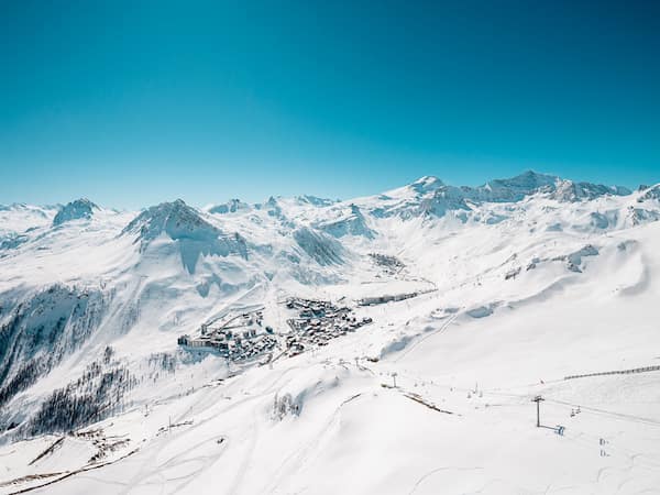 Vue en contreplongée du village de Tignes et son domaine skiable dans un paysage enneigé.