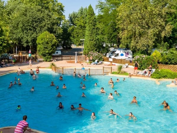Photographie de la piscine du camping d'Avignon avec des nageurs à l'intérieurs.