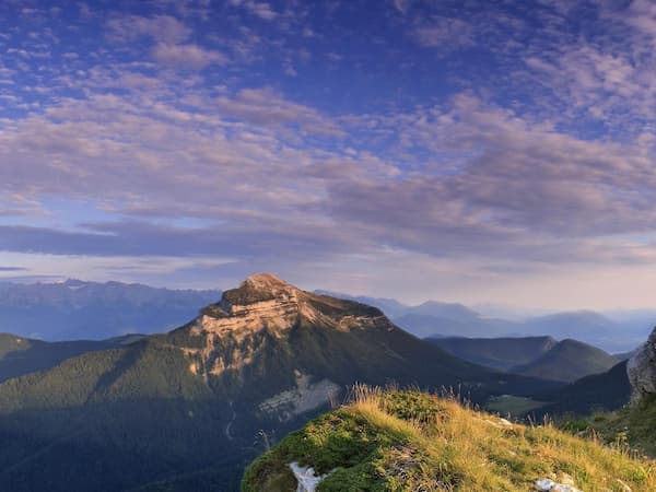 Paysage de montagne avec ciel bleu et massif montagneux.