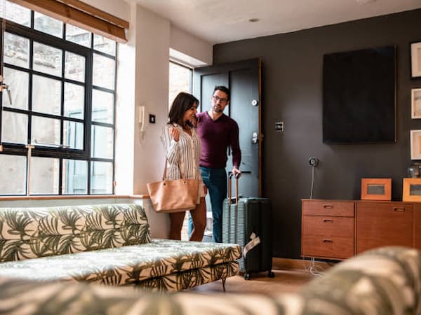 Photographie de vacanciers qui entrent dans un logement.